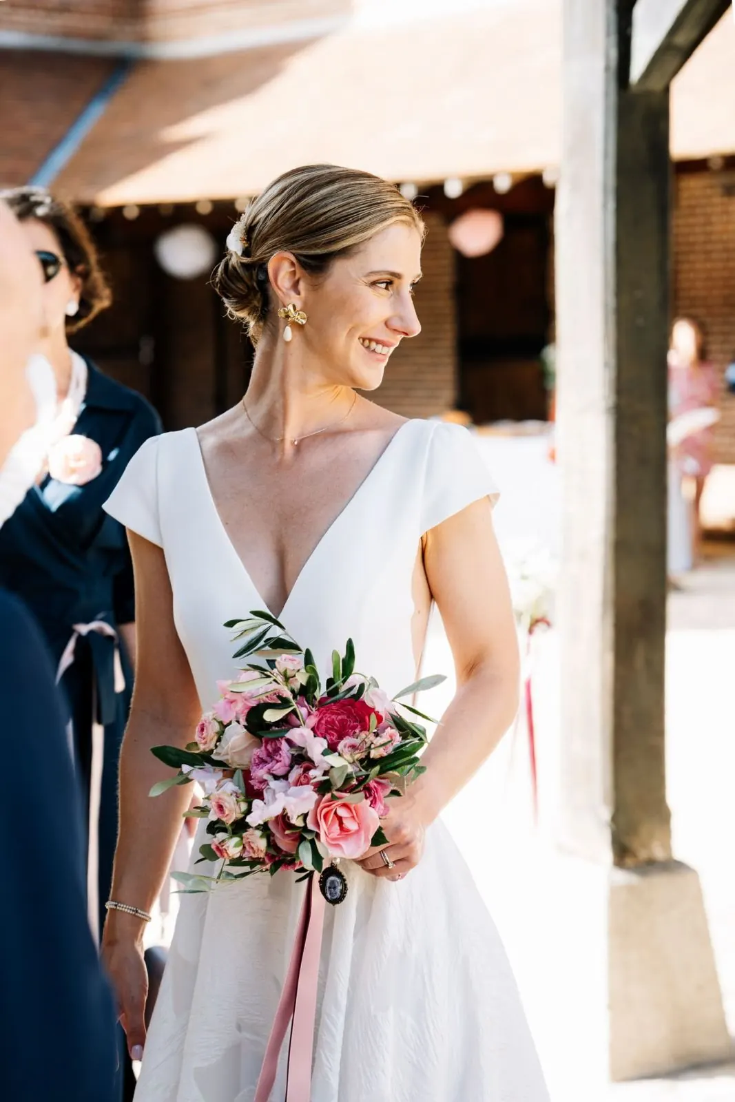 Mariée tenant un bouquet aux nuances roses et poudrées